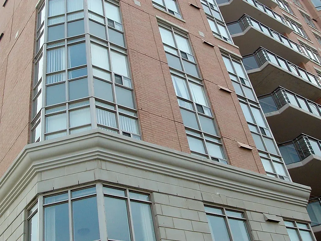 Corner window bay above layered horizontal facade bands