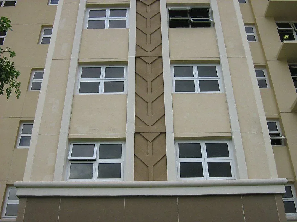 Vertical decorative panel between stacked windows on a pale facade