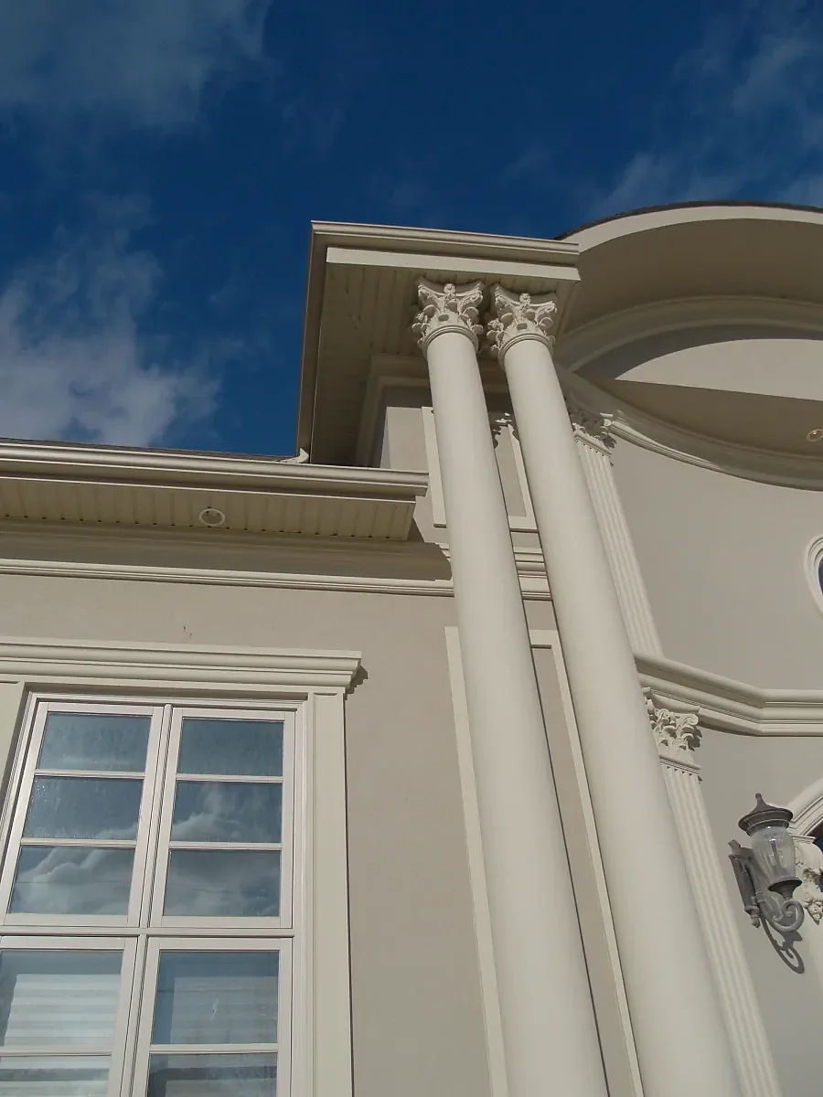 Fluted columns meeting a curved balcony and roofline cornice