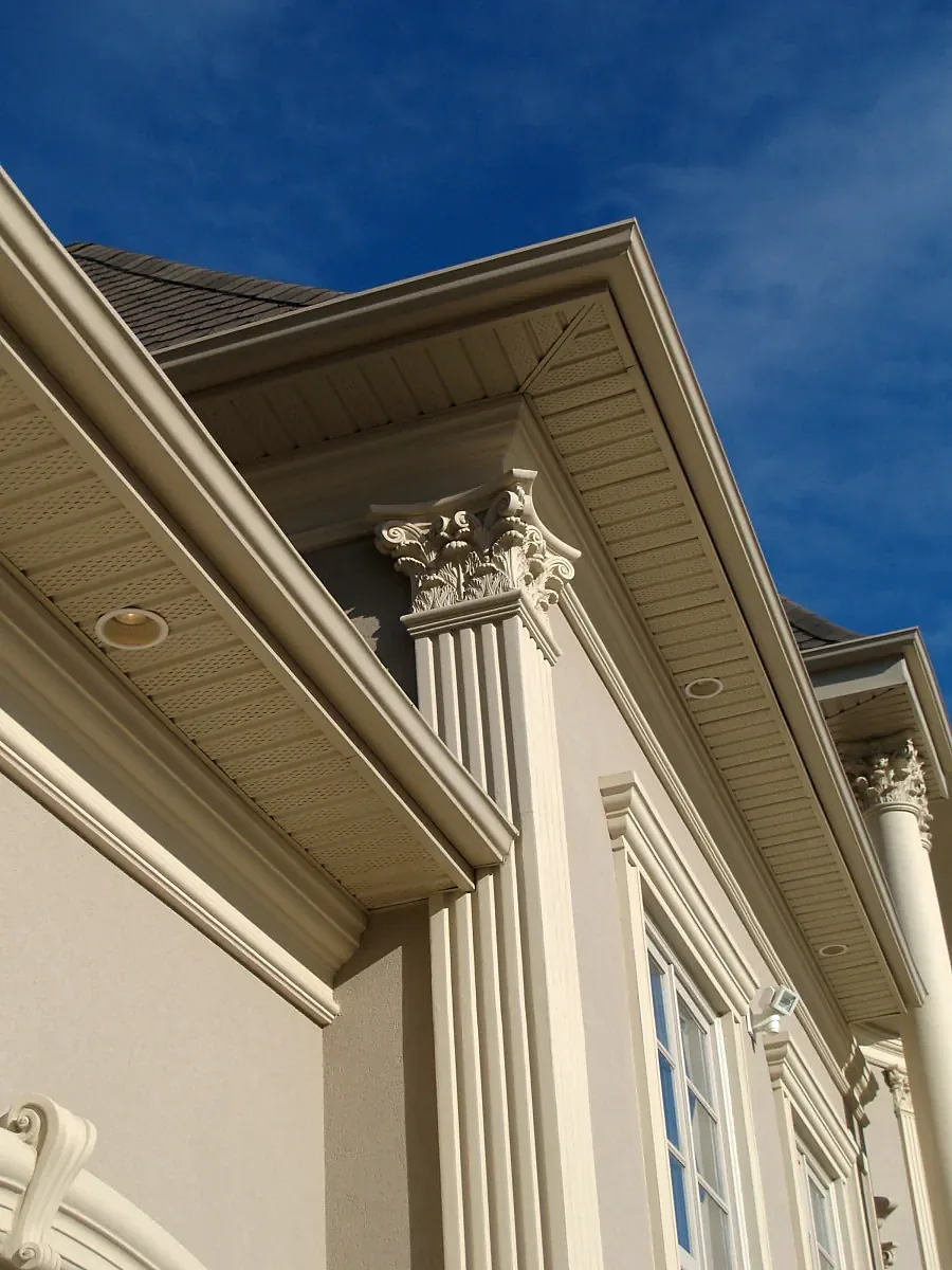 Close view of a projecting cornice above a pilaster and window