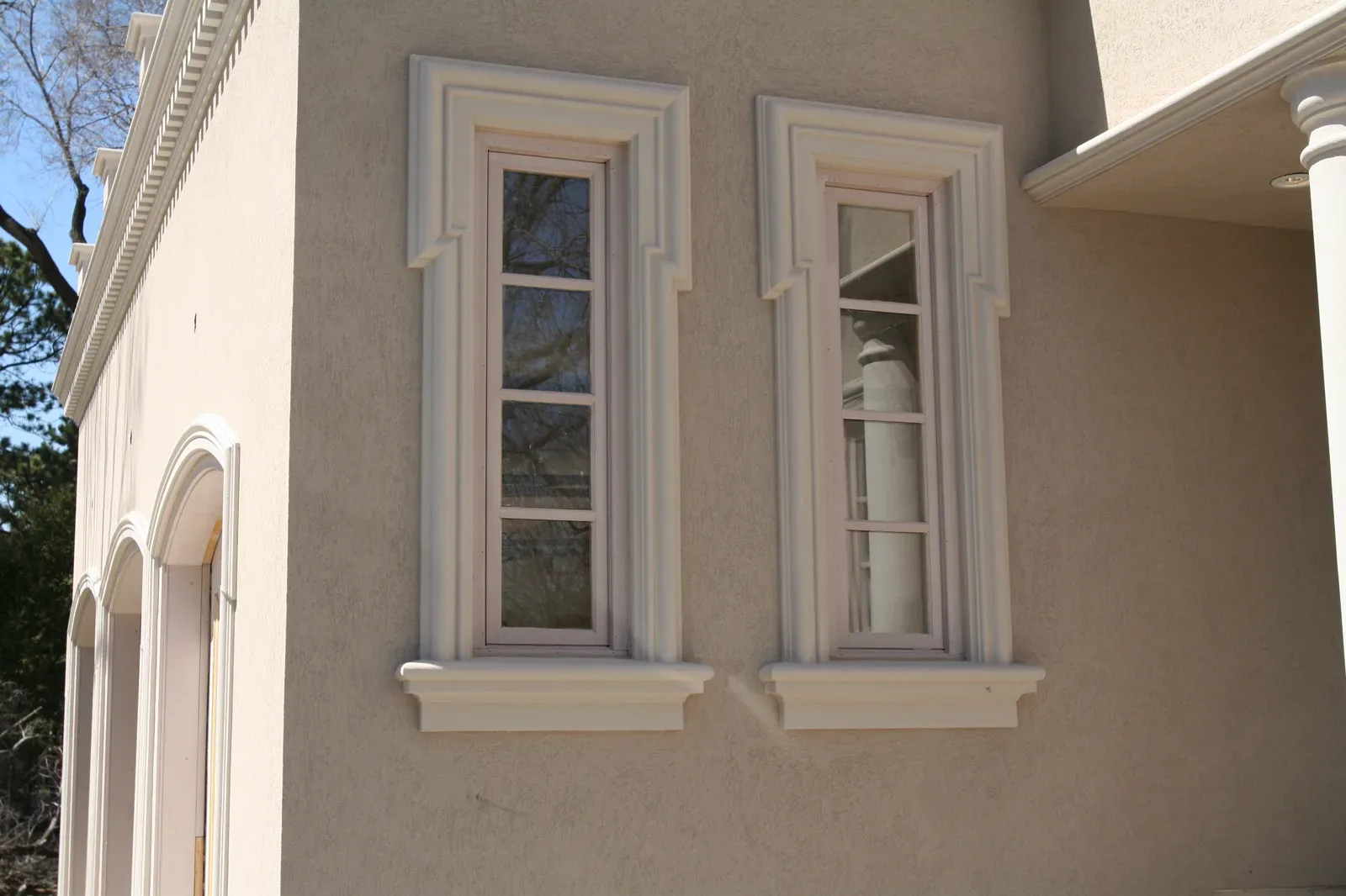 Exterior window surrounds with matching sills and cornice detail