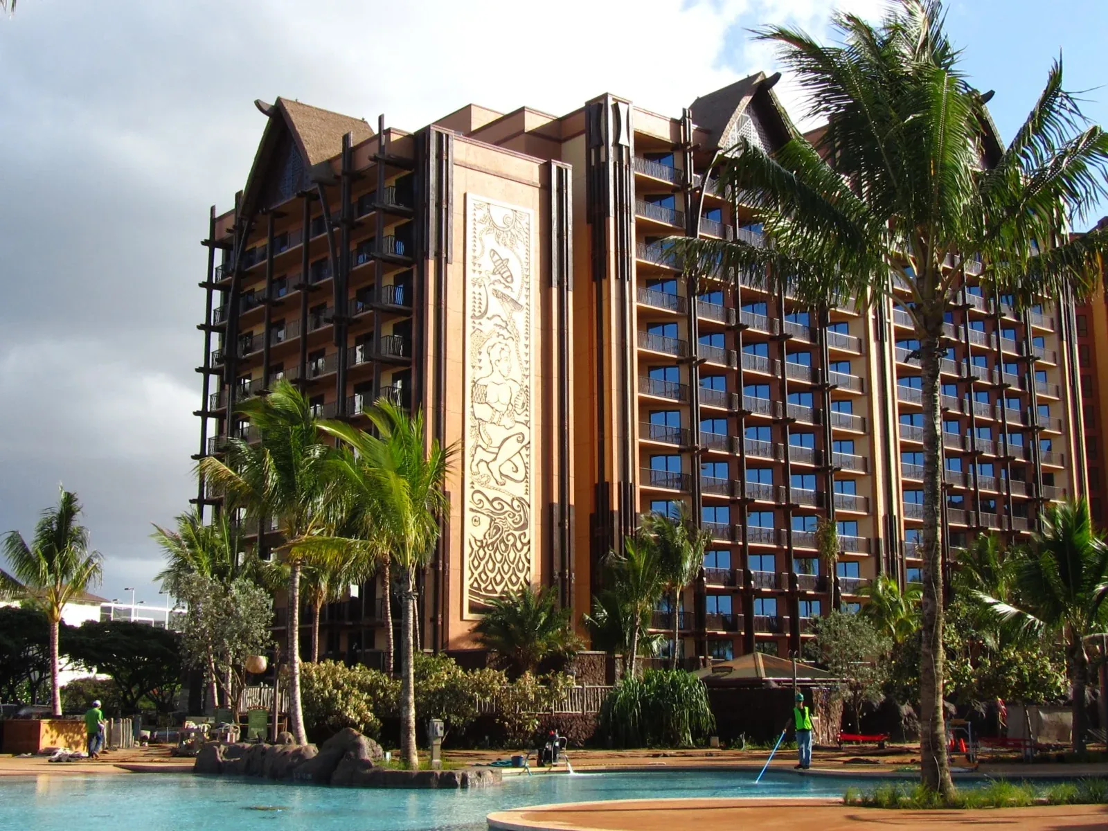 Tall building with balconies, decorative facade panels and landscaping
