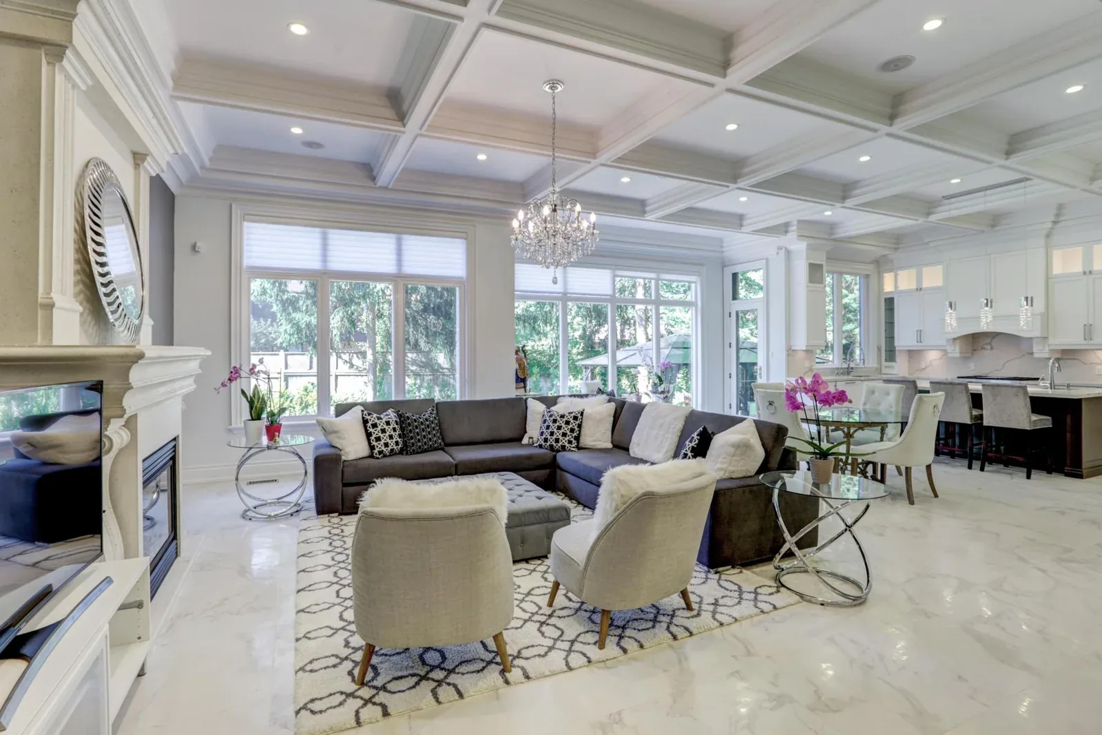 Open living space with coffered ceiling details and a chandelier