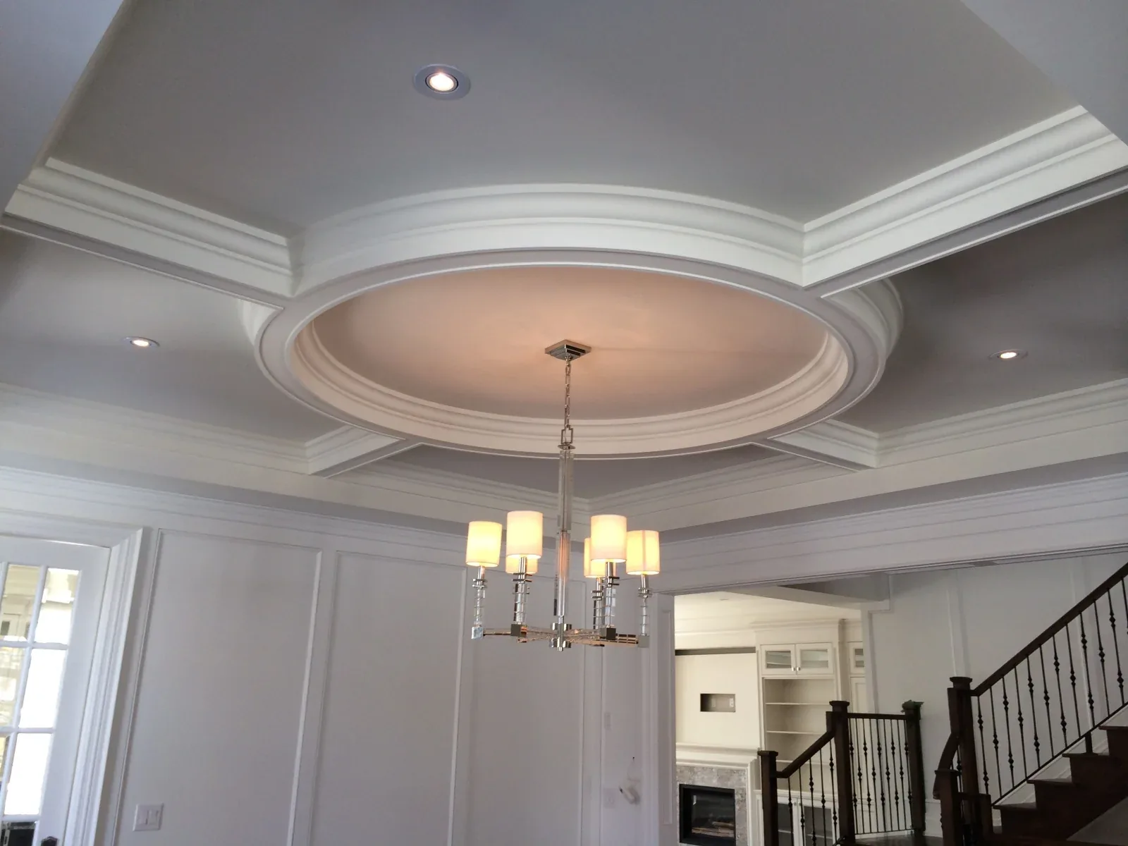 Circular ceiling feature with a pendant light and surrounding crown moulding