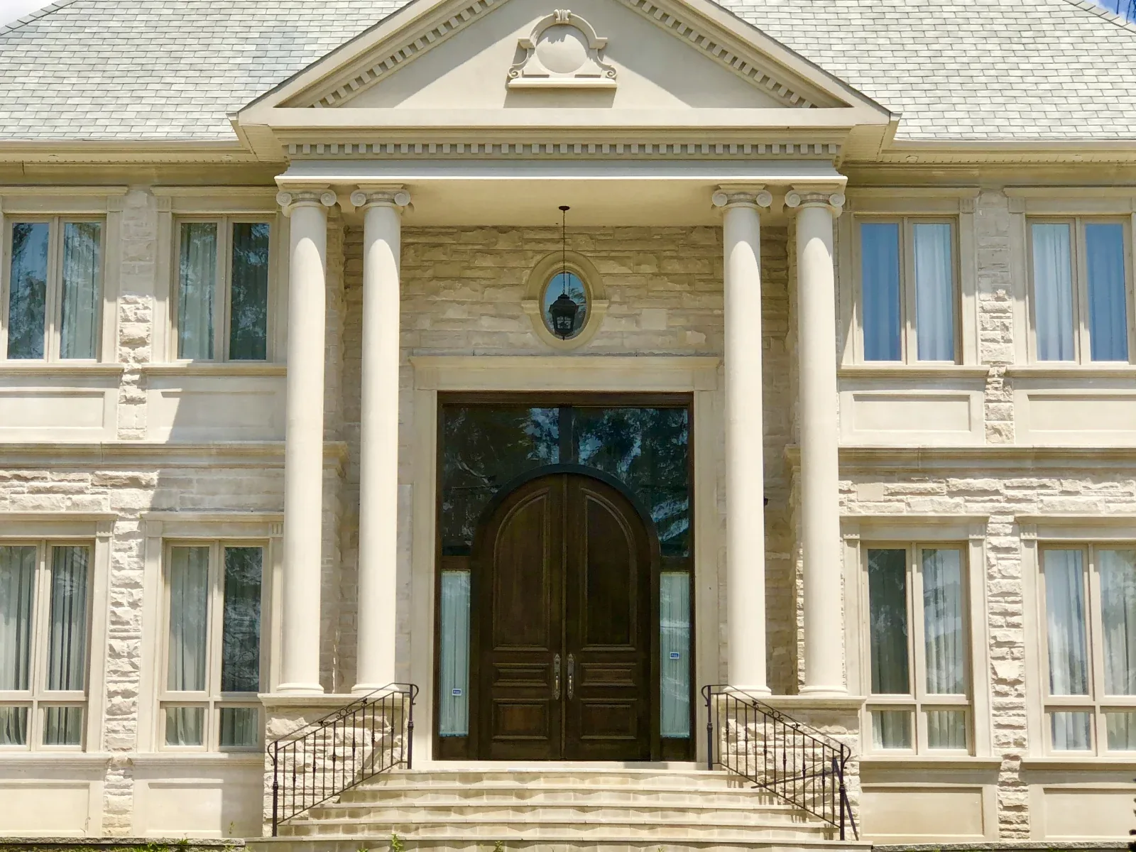 Residential entrance with columns, a pediment and an arched doorway