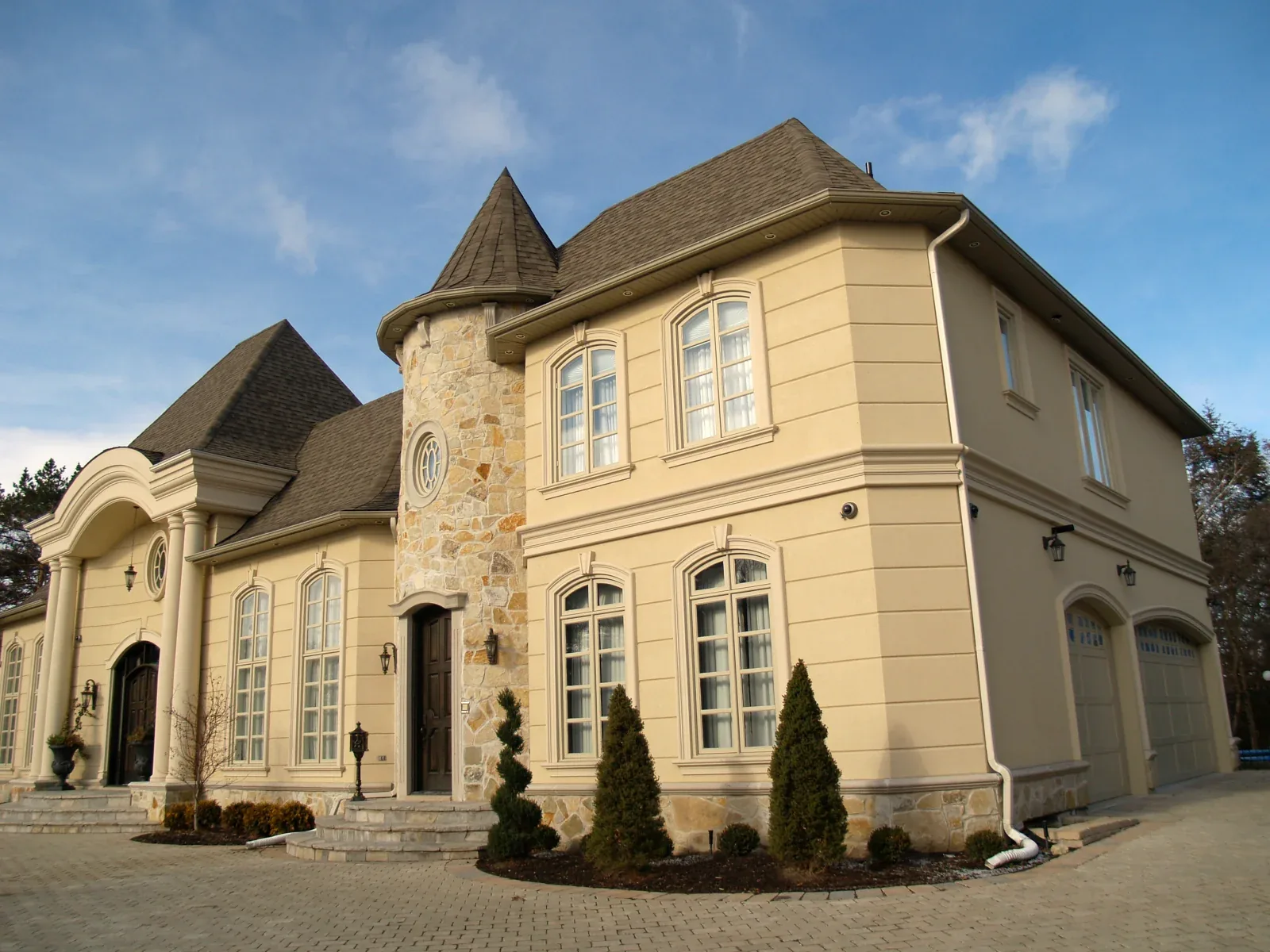 Residence with a curved bay, arched windows and horizontal facade bands